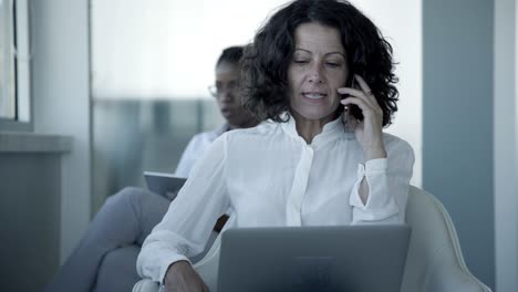 Serious-businesswoman-with-laptop-and-smartphone