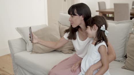 Fröhliche-Mutter-Und-Kleine-Tochter-Halten-Smartphone