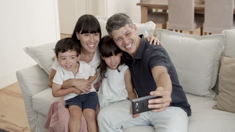 Glückliches-Elternpaar-Mit-Zwei-Kleinen-Kindern,-Die-Für-Ein-Selfie-Posieren