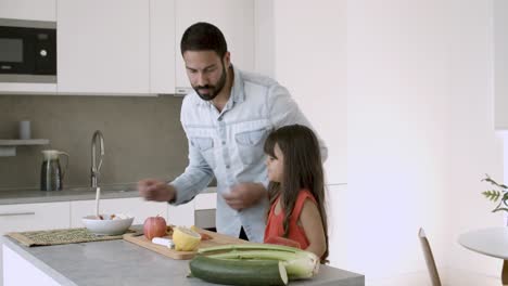 Handsome-dad-enjoying-cooking-dinner-with-little-daughter