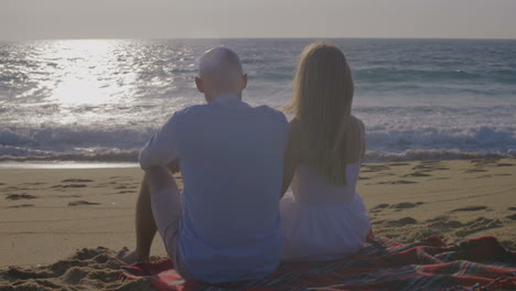 Couple-in-love-looking-at-sunset-at-seaside