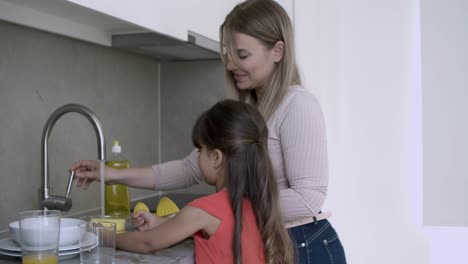 Adorable-girl-helping-mom-to-wash-dish
