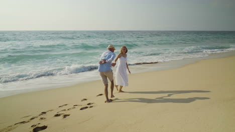 Happy-young-couple-having-fun-on-sandy-beach