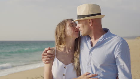 Happy-couple-kissing-on-sandy-beach