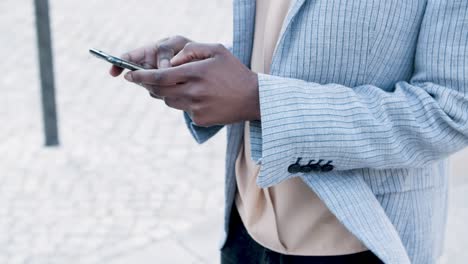 Cropped-view-of-woman-texting-on-smartphone-during-stroll