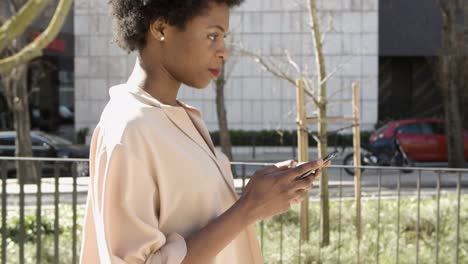 Seitenansicht-Einer-Afroamerikanischen-Frau,-Die-Auf-Dem-Smartphone-SMS-Schreibt