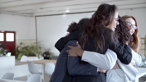 Team-of-multiethnic-businesswomen-hugging-in-office