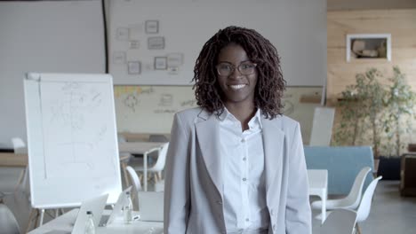 Cheerful-African-American-businesswoman-smiling-at-camera
