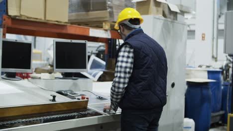Trabajador-Masculino-Maduro-Configurando-La-Máquina-De-Impresión