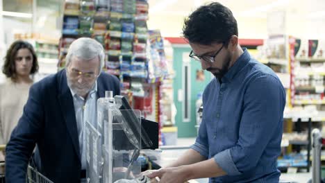 Mature-man-at-cash-register-in-supermarket