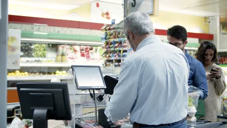 Cajero-Y-Compradores-En-Caja-Registradora-En-El-Supermercado