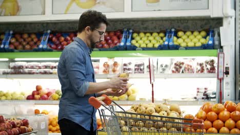 Man-buying-organic-fruits-in-supermarket
