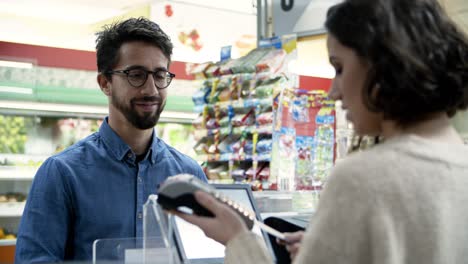 Smiling-man-paying-with-credit-card-in-store