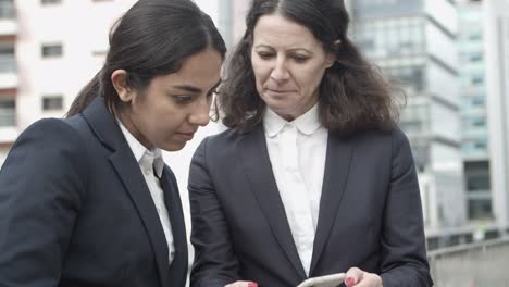 Businesswomen-using-smartphone-on-street