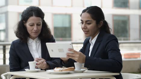 Lächelnde-Geschäftsfrauen-Mit-Tablet-PC-Im-Straßencafé