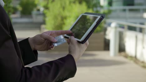 Young-male-hands-putting-bank-card-data-on-tablet,-paying-online