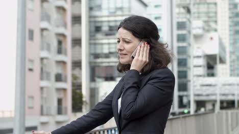 Ernsthafte-Geschäftsfrau,-Die-Per-Smartphone-Spricht