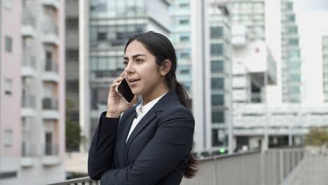 Young-businesswoman-talking-by-smartphone
