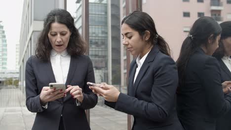 Businesswomen-talking-and-using-smartphones