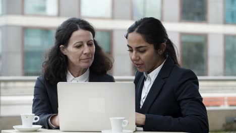 Businesswomen-using-laptop-computer-in-cafe