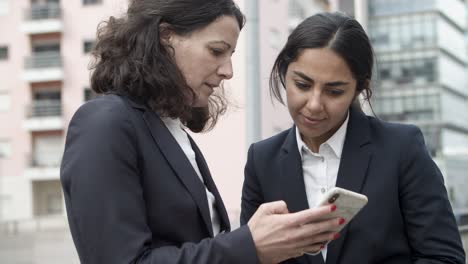 Konzentrierte-Geschäftsfrauen-Nutzen-Smartphone