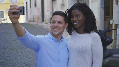 Smiling-young-couple-taking-selfie-with-smartphone.