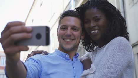 Happy-young-multiracial-couple-posing-for-selfie-outdoor.