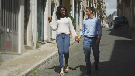 Smiling-multiracial-couple-walking-on-street-during-date.