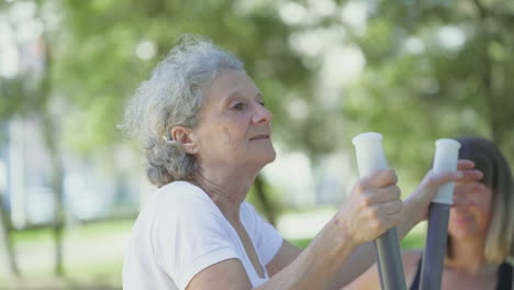 Smiling-elderly-woman-training-in-summer-park.