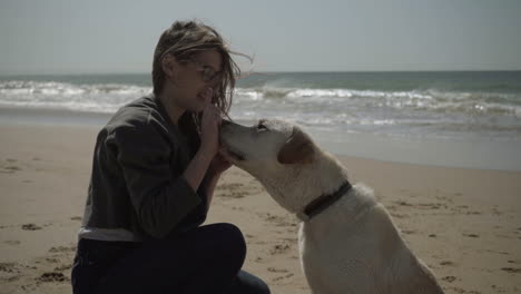 Slow-motion-shot-of-wet-dog-giving-paws-to-female-owner.