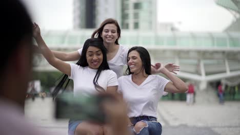 Mujeres-Sonrientes-Posando-Para-Una-Foto-Mientras-Están-Sentadas-En-La-Plaza.