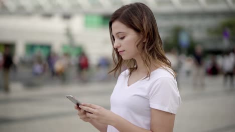 Beautiful-young-woman-using-smartphone-on-street