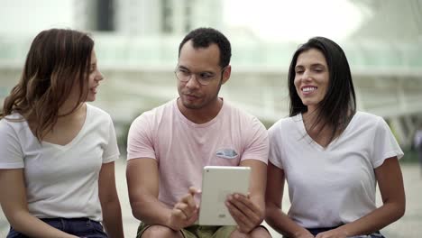 Front-view-of-cheerful-friends-using-tablet
