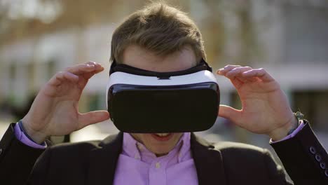Smiling-young-man-taking-off-VR-glasses