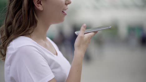 Cropped-shot-of-woman-using-smartphone-voice-recognition