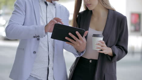 Male-and-female-colleagues-using-tablet-pc-outdoor