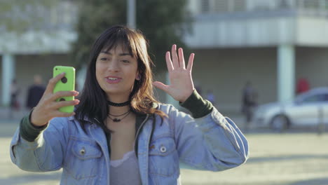 Smiling-teen-girl-waving-to-camera-and-showing-thumb-up.