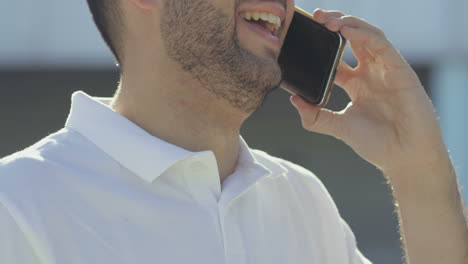 Cropped-shot-of-smiling-young-man-talking-on-phone.