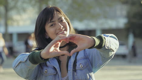 Smiling-teen-girl-making-heart-shape-with-hands