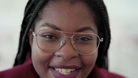 Close-up-shot-of-Afro-American-attractive-young-girl-with-plump-rose-lips-and-braids-in-aviator-eyeglasses-wearing-rose-coat