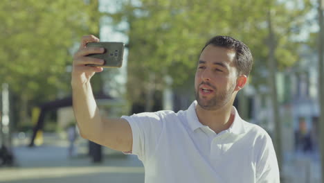 Cheerful-bearded-blogger-recording-video-with-smartphone.