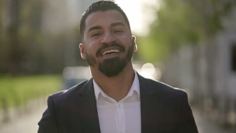 Cheerful-bearded-businessman-looking-at-camera-outdoor