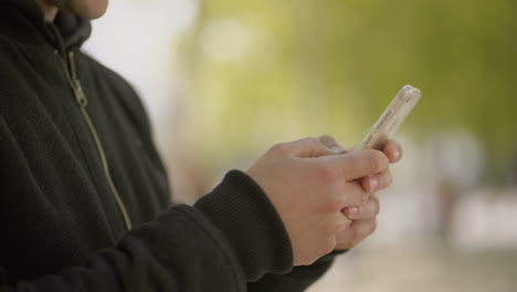 Cropped-shot-of-man-using-cell-phone-outdoor