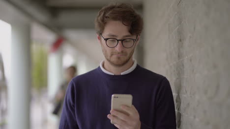 Handsome-bearded-man-using-smartphone-outdoor