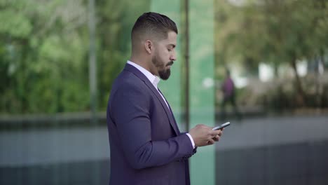 Fokussierter-Geschäftsmann,-Der-Per-Smartphone-SMS-Schreibt