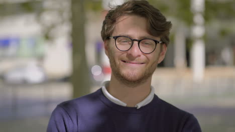 Cheerful-man-in-eyeglasses-looking-at-camera-outdoor