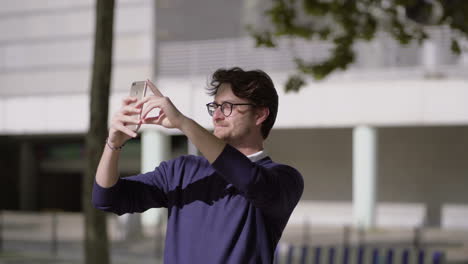 Man-in-eyeglasses-using-smartphone-on-street