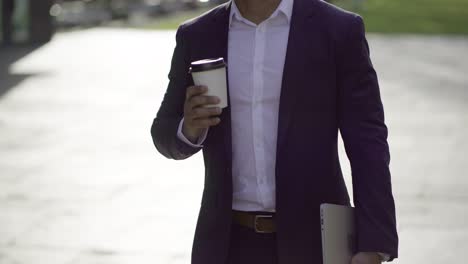 Businessman-with-laptop-and-coffee-to-go-on-street