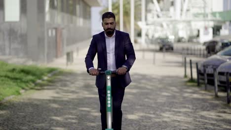 Serious-businessman-riding-scooter-on-street