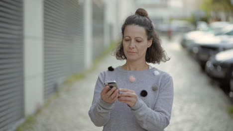Smiling-middle-aged-woman-using-smartphone-outdoor.